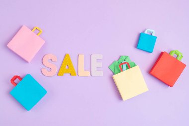 Kelime satışı ve alışveriş poşetleri. Sesonal satış, online anlaşmalar, indirimler, promosyon, alışveriş bağımlılığı konsepti
