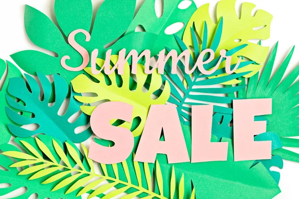 Word Summer Sale over tropical paper cut leaves background. Summer sale, online deals, discounts concept.