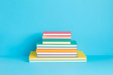 Renkli kitap ve defterler yığını. Eğitim, öğrenim, öğrenim, okula dönüş, öğretim kavramı