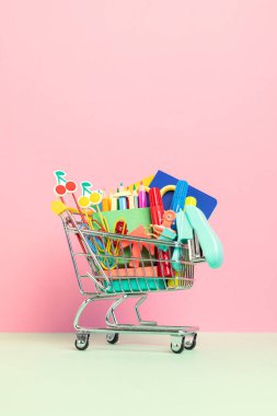 Okul malzemeleriyle dolu bir alışveriş arabası. Okula hazırlık, alışveriş, satış, anlaşmalar, indirimler, tanıtım konsepti