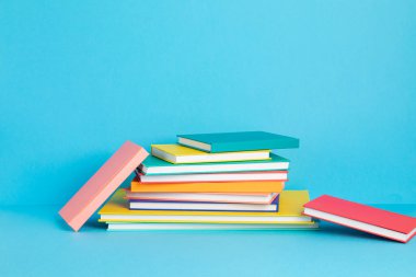 Renkli kitap ve defterler yığını. Eğitim, öğrenim, öğrenim, okula dönüş, öğretim kavramı
