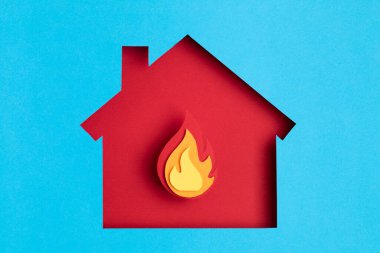 İçinde ateş olan kağıt kesimi bir ev. Ev sigortası, güvenlik, güvenlik, hasar, kaza önleme kavramı