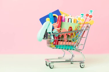 Okul malzemeleriyle dolu bir alışveriş arabası. Okula hazırlık, alışveriş, satış, anlaşmalar, indirimler, tanıtım konsepti
