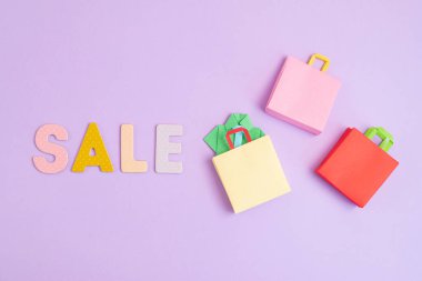 Kelime satışı ve alışveriş poşetleri. Sesonal satış, online anlaşmalar, indirimler, promosyon, alışveriş bağımlılığı konsepti