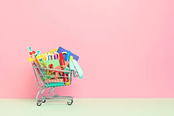 Shopping trolley full of school supplies. Preparation to school, shopping, sale, deals, discounts, promotion concept