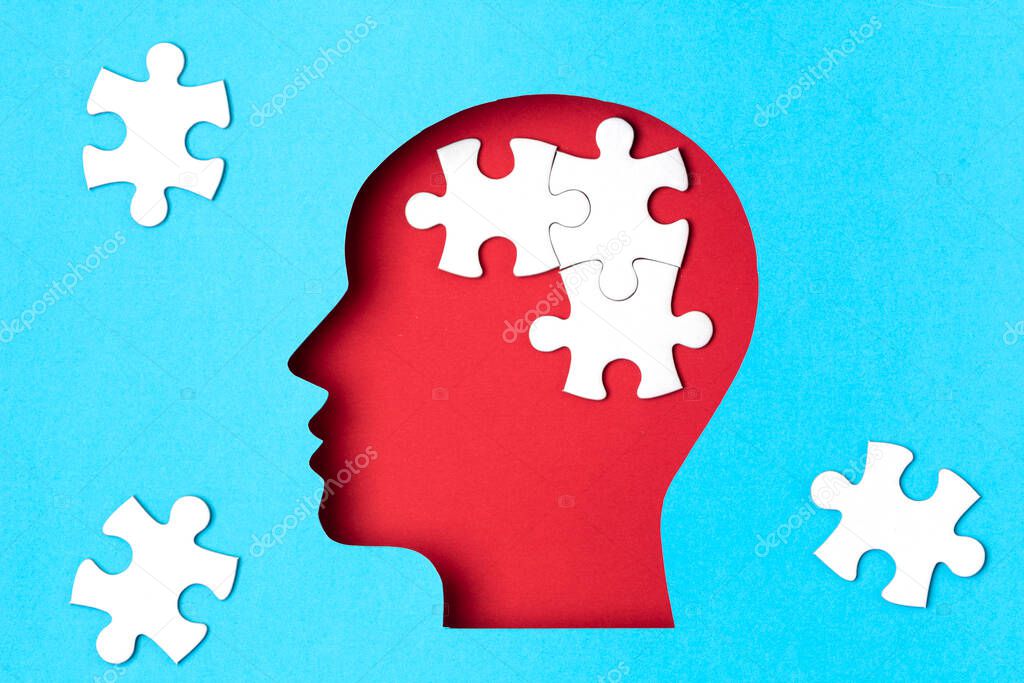 Papercut head with jigsaw puzzle pieces inside. Mental health problems, psychology, memory, logic, thinking process, solution, mental illness concept