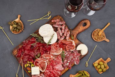 Farklı aperatifler, antipasti, şarküteri, aperatif ve şarap. Sosis, jambon, tapas, zeytin, peynir ve açık büfe partisi için kraker. Üst manzara, düz uzanma