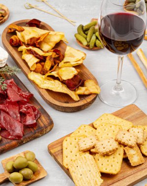 Farklı aperatifler, antipasti, şarküteri, aperatif ve şarap. Sosis, jambon, tapas, zeytin, peynir ve açık büfe partisi için kraker. Üst manzara, düz uzanma