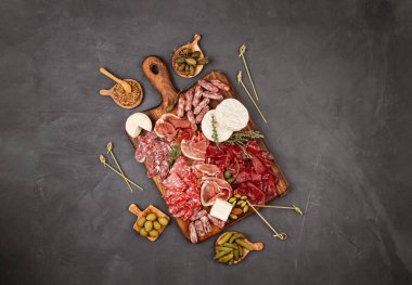 Farklı aperatifler, antipasti, şarküteri, aperatif ve şarap. Sosis, jambon, tapas, zeytin, peynir ve açık büfe partisi için kraker. Üst manzara, düz uzanma