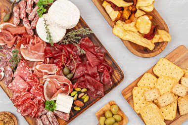Farklı aperatifler, antipasti, şarküteri, aperatif ve şarap. Sosis, jambon, tapas, zeytin, peynir ve açık büfe partisi için kraker. Üst manzara, düz uzanma