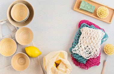 Sıfır atık. Çevre dostu bambu çatal bıçak takımı, ağ pamuk torbası, yeniden kullanılabilir kahve bardağı, fırçalar ve su şişesi. Sürdürülebilir, etik, plastik içermeyen konsept