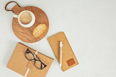 Organik renkli durağan, kahve fincanı olan küçük bir masaüstü modeli. Serbest çalışan, sosyal medya blogcusu konsepti. Düz konum, üst görünüm, kopyalama alanı.