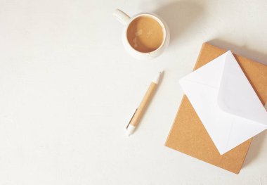 Organik renkli durağan, kahve fincanı olan küçük bir masaüstü modeli. Serbest çalışan, sosyal medya blogcusu konsepti. Düz konum, üst görünüm, kopyalama alanı.