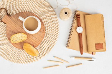 Organik renkli durağan, kahve fincanı olan küçük bir masaüstü modeli. Serbest çalışan, sosyal medya blogcusu konsepti. Düz konum, üst görünüm, kopyalama alanı.