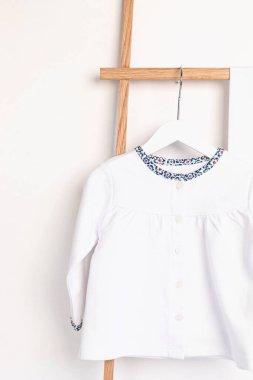 Askıda asılı şirin yeni doğan giysileri. Organik pamuk bebek giysisi modeli.