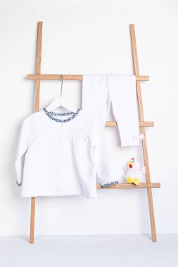 Askıda asılı şirin yeni doğan giysileri. Organik pamuk bebek giysisi modeli.