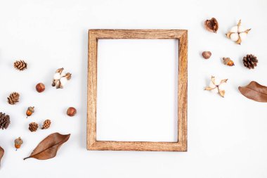 Sonbahar düz kompozisyonu. Resim çerçevesi, açık gri arka planda kurumuş yapraklar ve fındıklar. Sonbahar, sonbahar konsepti. Model, üst görünüm, kopyalama alanı