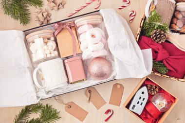 Bakım paketi, mevsimlik hediye paketi içinde marşmelov, çay, kahve ya da kakao kutusu ve Noel süsü. Kış tatili için kişisel çevre dostu sepet. Üst manzara, düz uzanma