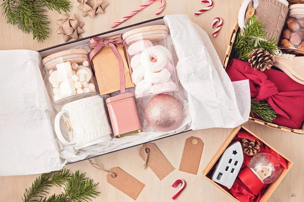 Bakım paketi, mevsimlik hediye paketi içinde marşmelov, çay, kahve ya da kakao kutusu ve Noel süsü. Kış tatili için kişisel çevre dostu sepet. Üst manzara, düz uzanma