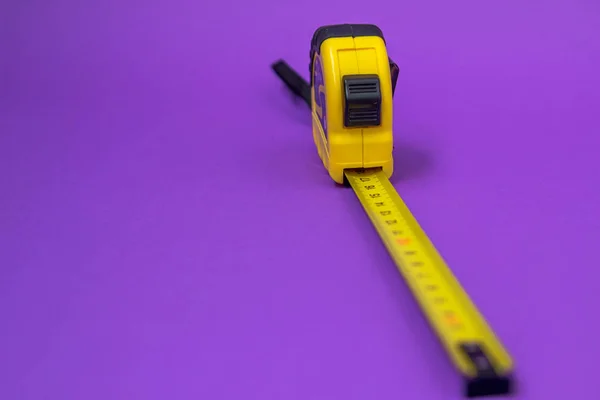 Hand tool Roulette construction yellow on purple background — Stock Photo, Image