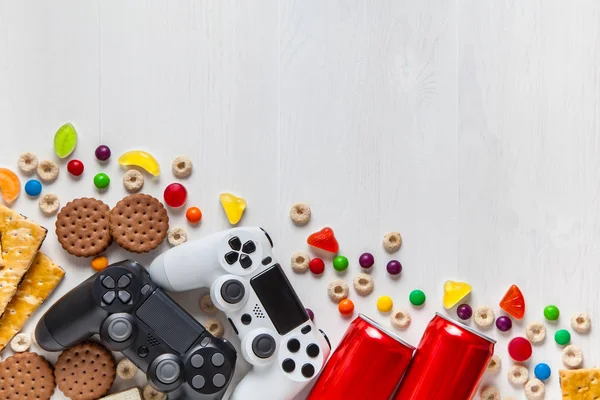 お菓子 ビスケット ソーダの缶の中で白い木製の背景に黒と白のモダンなゲームパッド フラット レイアウト コピー スペース ゲームのコンセプト — ストック写真