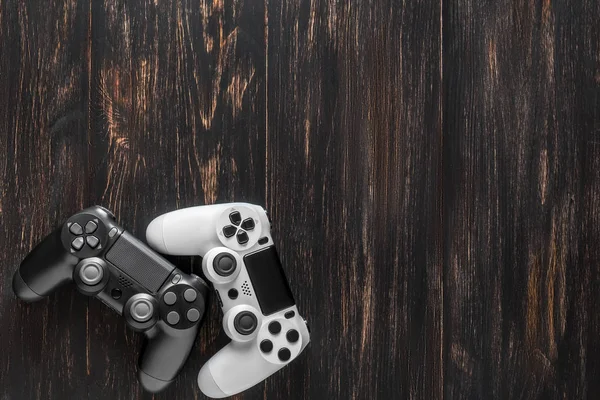 Koyu Ahşap Arka Plan Üzerinde Siyah Beyaz Modern Gamepads — Stok fotoğraf