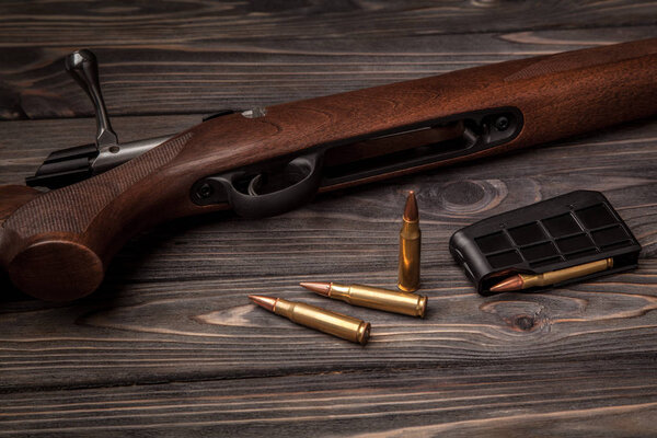 Hunting rifle on a dark wooden background