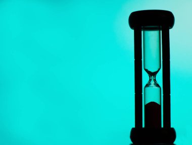 zaman doldu. kum saati. siluet. mavi arka plan.