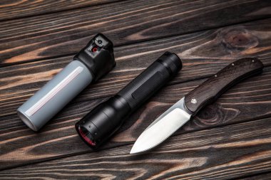 el feneri, biber gazı ve koyu ahşap arka plan üzerinde bıçak. kendini savunma için ayarla