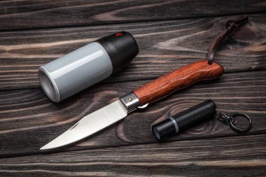 el feneri, biber gazı ve koyu ahşap arka plan üzerinde bıçak. kendini savunma için ayarla