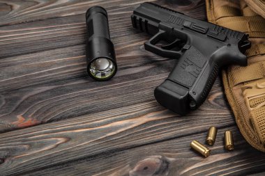 siyah tabanca, el feneri ve bir kahverengi ahşap arka plan kartuşları