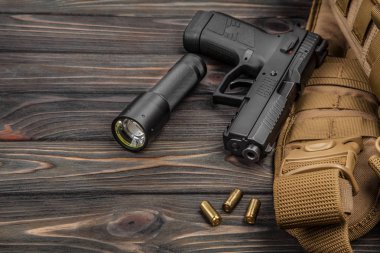 siyah tabanca, el feneri ve bir kahverengi ahşap arka plan kartuşları