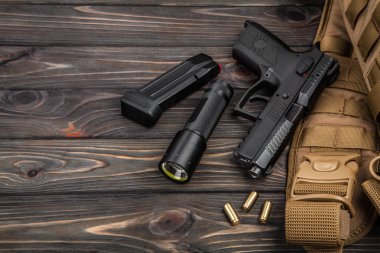 siyah tabanca, el feneri ve bir kahverengi ahşap arka plan kartuşları