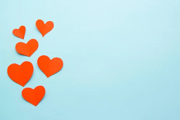 red paper hearts on a blue paper background