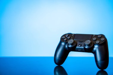 modern siyah gamepad parlak bir yüzey ve bir parlayan mavi arka plan