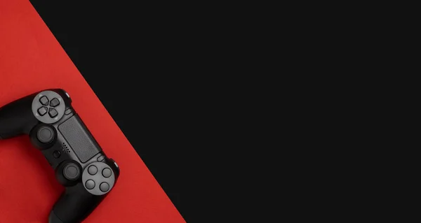 黒赤の背景に黒のゲームパッド ゲームのコンセプト — ストック写真