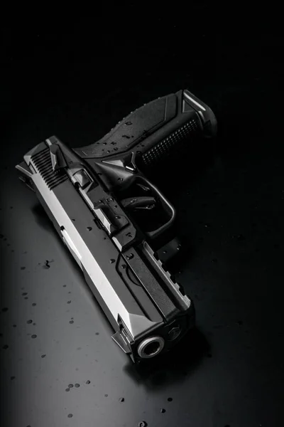 Moderne schwarze Pistole auf schwarzem Rücken — Stockfoto