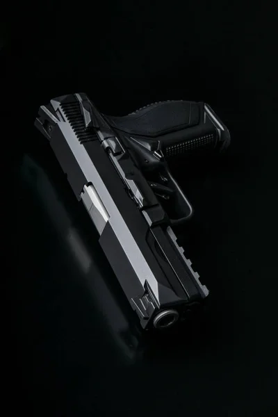 Moderne zwarte pistool op zwarte rug — Stockfoto