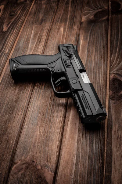 Czarny pistolet na brązowy drewniany stół — Zdjęcie stockowe