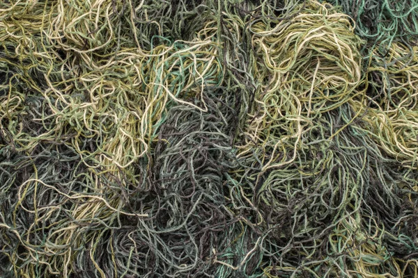 Bakgrund av färgade trådar kaotiskt sammanflätade. grön FöPL- — Stockfoto
