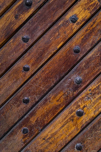 Close up of old vintage wooden door with metal furniture.  Brown