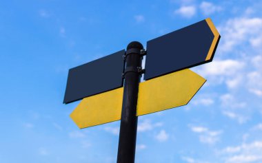 Mavi gökyüzüne karşı sarı yön işareti. Sarı a