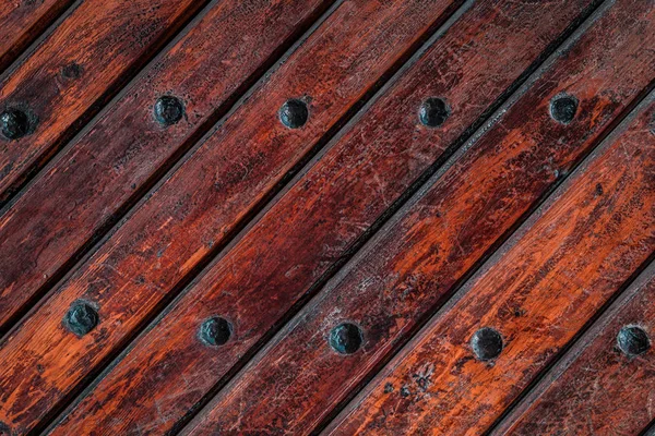 Close up of old vintage wooden door with metal furniture.  Brown