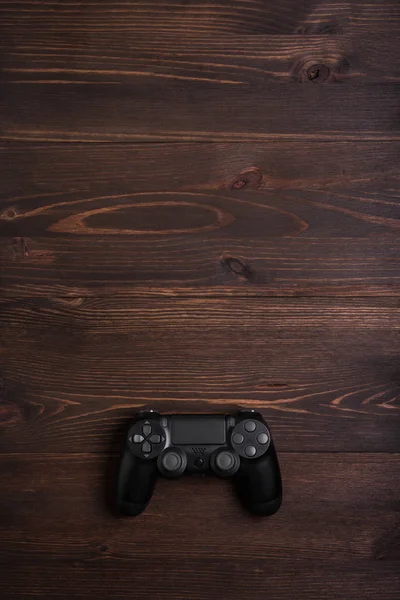 Gamepad preto moderno em um fundo de madeira escura. Conceito de jogo w — Fotografia de Stock