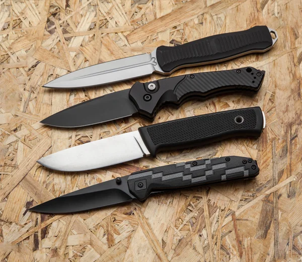 Diversi coltelli da caccia e pennini su uno sfondo di legno chiaro — Foto Stock