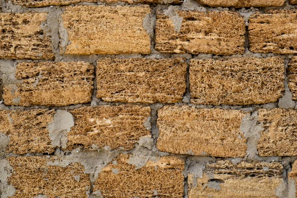 Ziegelmauer aus gelbem Muschelgestein. Nahaufnahme von Muschelsteinen. — Stockfoto