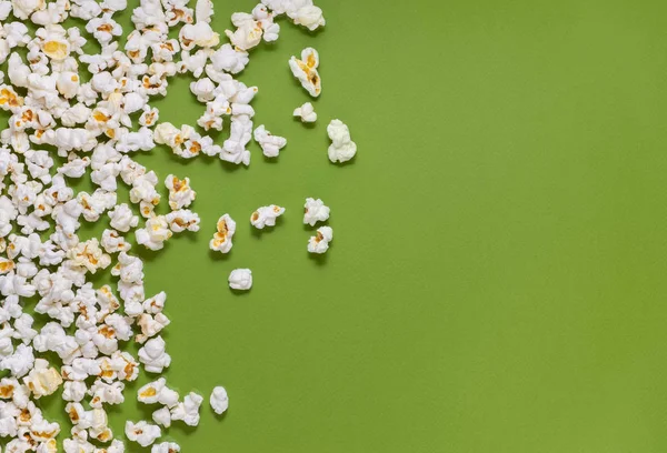 White tasty popcorn on a green background. Popcorn pattern on gr — Stock Photo, Image