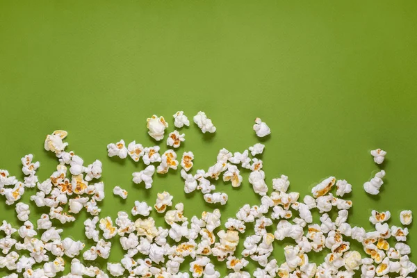 White tasty popcorn on a green background. Popcorn pattern on gr — Stock Photo, Image