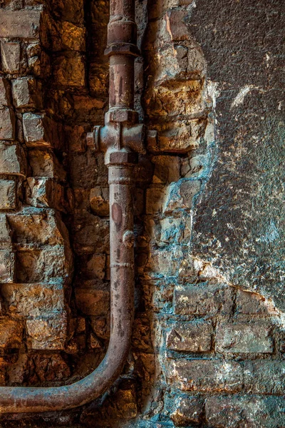 Vecchio tubo di acqua arrugginita in un muro di mattoni. Vecchio tubo arrugginito con valvola — Foto Stock