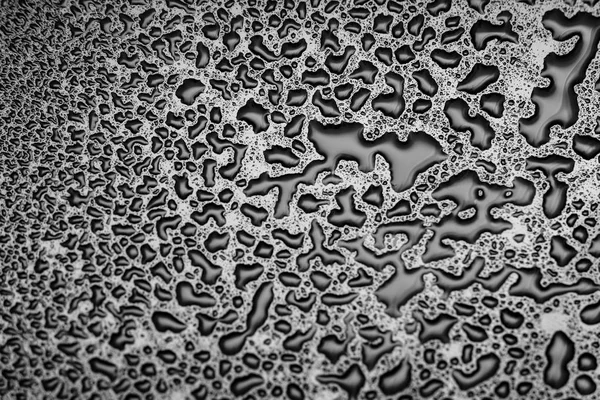 Glänzende Wassertropfen auf ein dunkles Glas. Wassertropfen auf schwarzer Oberfläche. — Stockfoto
